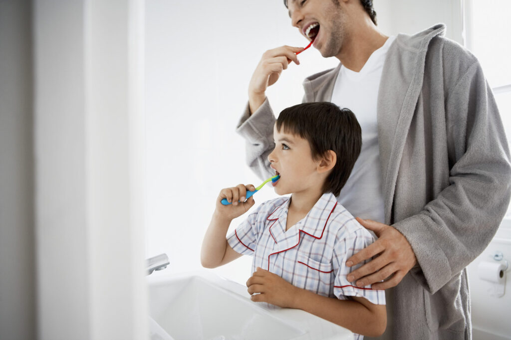 Father and son brushing their teeth